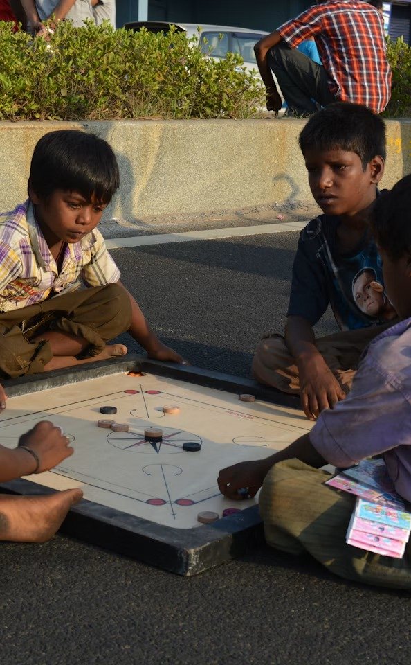 Children playing carrom on the street